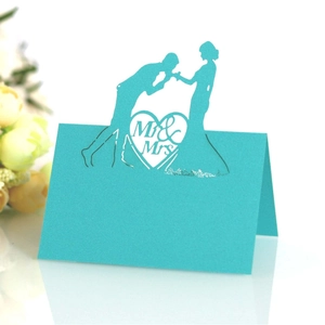 Teal laser-cut wedding place cards featuring Mr & Mrs heart silhouette for table settings