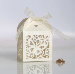 Macro shot of laser-cut butterfly gift box with elegant ivory hollow pattern and ribbon