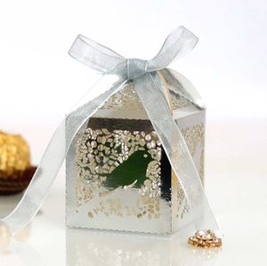 Macro shot of silver laser-cut candy box featuring bird patterns and light blue ribbon