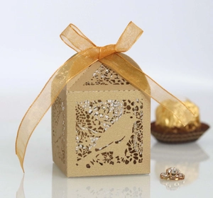 Detailed laser cut gold favor box with bird pattern and golden organza ribbon bow