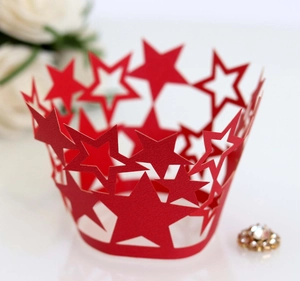 Detalle de patrón de estrellas cortado con láser en moldes de cartón rojo para cupcakes