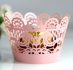 Close-up of pink laser-cut lace cupcake wrapper with intricate floral petal patterns