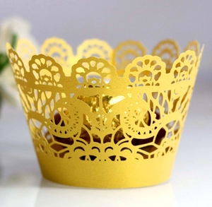 Close-up of yellow laser-cut lace cupcake wrapper with intricate floral patterns