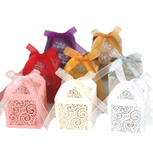 Elegant laser-cut wedding favor boxes with satin ribbons in various pastel colors