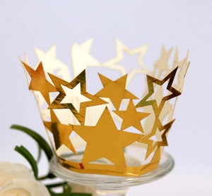 Detalle de moldes dorados para cupcakes con diseño de estrellas cortadas por láser en mesa