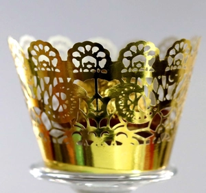 Macro view of gold laser-cut lace cupcake wrappers with elegant floral hollow patterns
