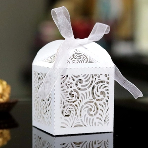 Elegante caja blanca para dulces de boda cortada con láser con cinta y patrones calados