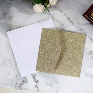 Elegant square gold glitter and white wedding invitations on marble background