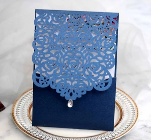 Detail of laser-cut rose hollow invitation card in navy blue with a teardrop rhinestone
