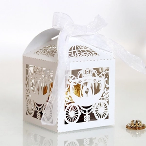 Elegant white laser-cut carriage wedding favor box with a delicate white organza ribbon bow