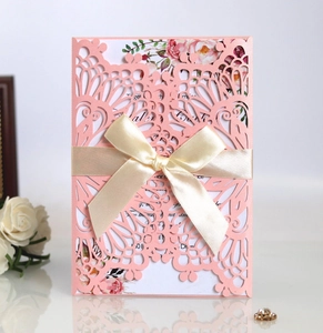 Pink laser-cut wedding invitation with floral inner card and beige silk ribbon bow