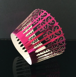 Detail of pink metallic laser-cut lace cupcake wrapper with elegant hollow heart patterns