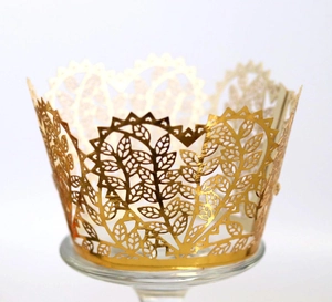 Detailed laser-cut gold cupcake wrapper with intricate heart and leaf patterns