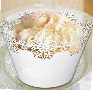 Close-up of white laser-cut cupcake wrappers with snowflake patterns for Christmas