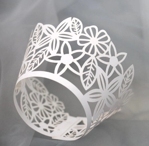 Laser-cut white cupcake wrappers with elegant floral hollow patterns for party decor