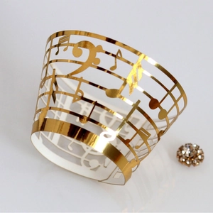 Laser-cut gold music note cupcake wrappers with hollow musical staff design for decoration