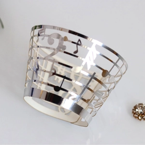 Laser-cut silver cupcake wrappers featuring musical notes and staff theme decor