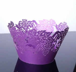 Detail of laser-cut purple cupcake wrappers featuring intricate grape and vine patterns
