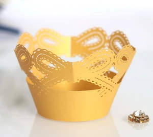 Golden laser-cut lace cupcake wrappers with elegant bow design for dessert decoration
