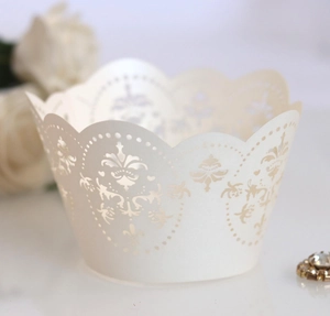 Detailed macro view of laser-cut lace cupcake wrapper with pearlescent ivory finish