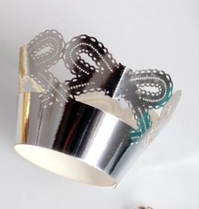 Macro shot of silver laser-cut crown lace cupcake wrappers with metallic finish details