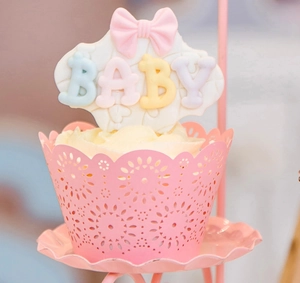 Detailed laser-cut pink lace cupcake wrapper with baby shower floral decoration