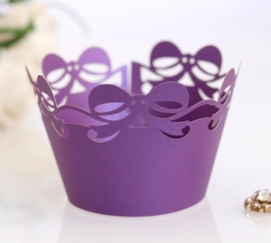 Macro view of purple laser-cut cupcake wrappers with delicate bow lace details