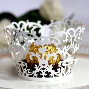 White laser cut cupcake wrappers with lace vine design for elegant party decor