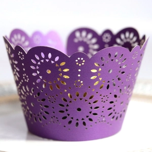 Intricate laser cut purple paper cupcake wrappers with floral and wave patterns for parties