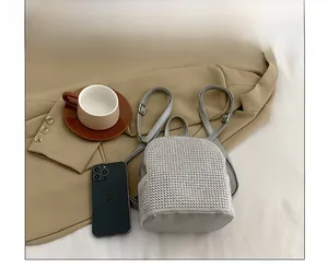Mini zaino con strass argentati confrontato con uno smartphone per la scala