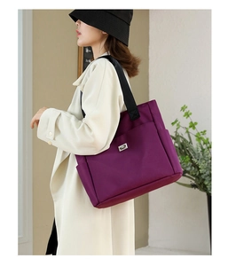 Detail of purple waterproof oxford tote bag with side pockets and black wide straps