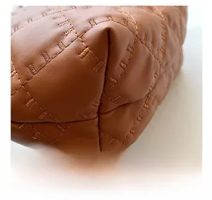 Dettaglio ravvicinato della borsa in pelle caramello con cuciture trapuntate a diamante