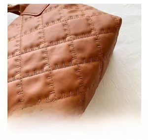 Dettaglio della borsa in pelle marrone con eleganti cuciture trapuntate e trama raffinata