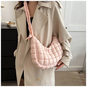 Detailed texture of pink quilted puffy shoulder bag with soft padded fabric and ruching