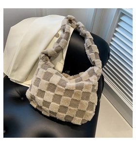Detail of plush checkered hobo bag in beige and taupe on a black leather chair
