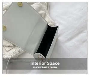 Close-up of the black interior compartment and golden magnetic closure of the white crossbody bag