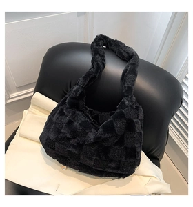 Close-up of black plush shoulder bag featuring a classic waffle texture and soft fur