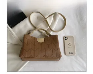 Detailed comparison of brown quilted shoulder bag with phone for size reference
