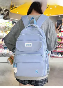 Detail of light blue waterproof backpack with fashion embroidery and burger plush charm