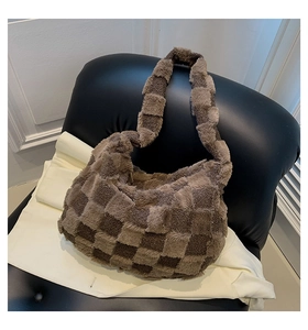 Close-up of fluffy brown checkered plush shoulder bag on a leather seat texture