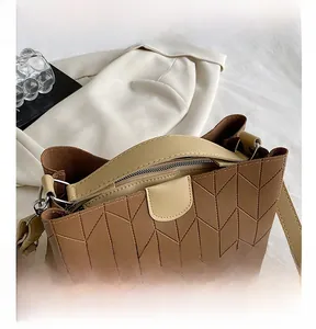 Detail of brown quilted tote bag with V-shaped stitching and adjustable strap