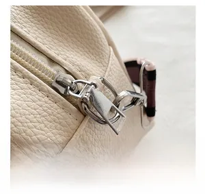 Detail view of smooth metal zipper and silver hardware on lychee pattern camera bag