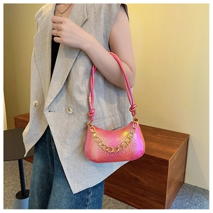 Detaillierte Nahaufnahme einer rosa Schultertasche mit Struktur und goldener Kette