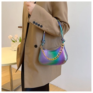 Detail einer holografischen Tasche mit Schlangenmuster und goldener Metallkette