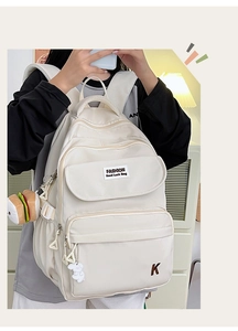Close-up of off-white waterproof backpack featuring fashion labels and cute bag charms