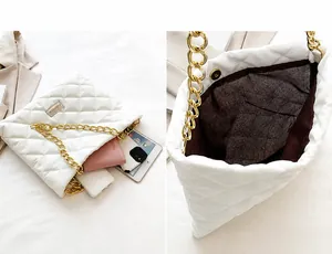 Detail showing white quilted bucket bag interior capacity and thick gold chain strap