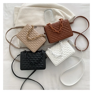 Detail of elegant quilted square bags with resin chains and fine shoulder straps