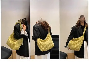 Detail of soft yellow cloud bag showing versatile carrying styles and bubble texture fabric