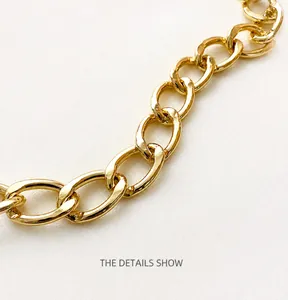 Detail view of high-shine gold metal chain strap for stylish crossbody or shoulder bags