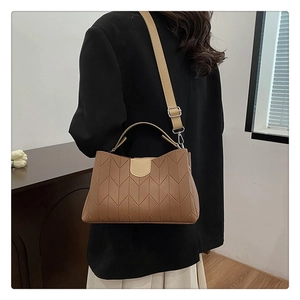 Detail view of a brown quilted leather handbag styled with professional office attire